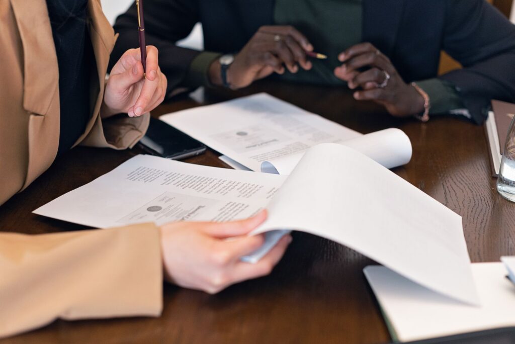 Close-up of professionals reviewing documents at a desk
